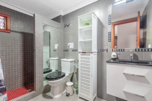 een badkamer met een toilet, een wastafel en een spiegel bij Encanto Arinaga in Cruce de Arinaga