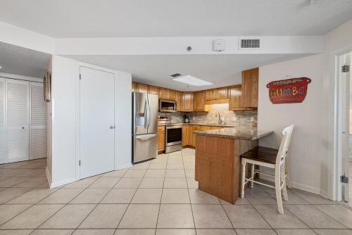 Una cocina con gabinetes de madera y encimera. en Phoenix 7 Unit 212, en Orange Beach