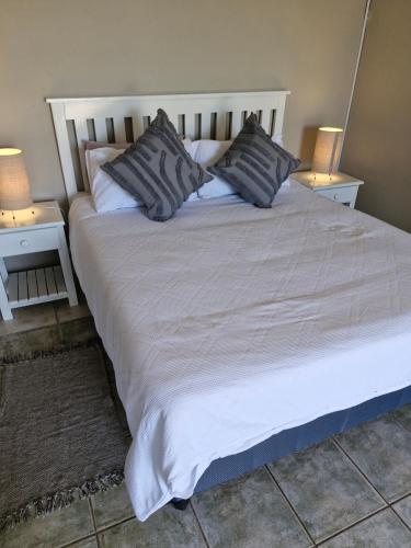a large white bed with two nightstands and two lamps at Spiros Beach Haven in Port Edward