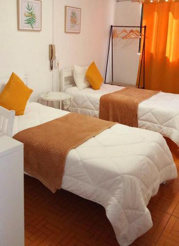 a hotel room with two beds and a couch at Hospedaria Pôr do Sol in Funchal