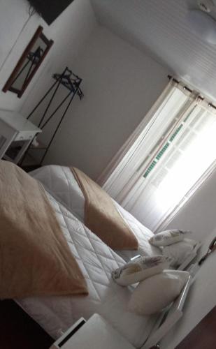 a bedroom with a bed with a window at Hospedaria Pôr do Sol in Funchal