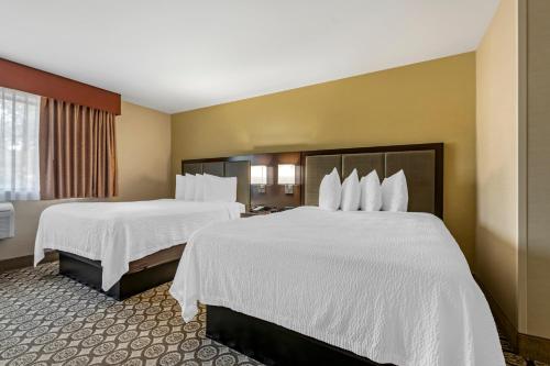 a hotel room with two beds with white sheets at Best Western Plus InnTowner Madison in Madison