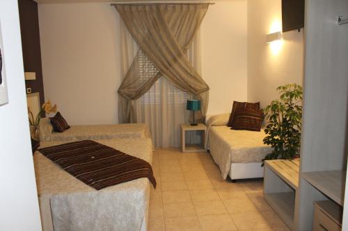 a hotel room with two beds and a window at Artemisia Palace Hotel in Palermo
