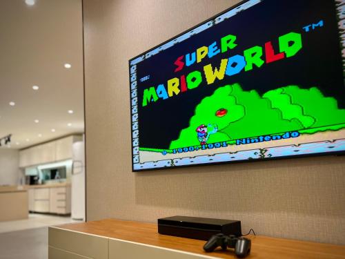 a tv on a wall with a video game on it at Residence Dunas Exclusive in Natal