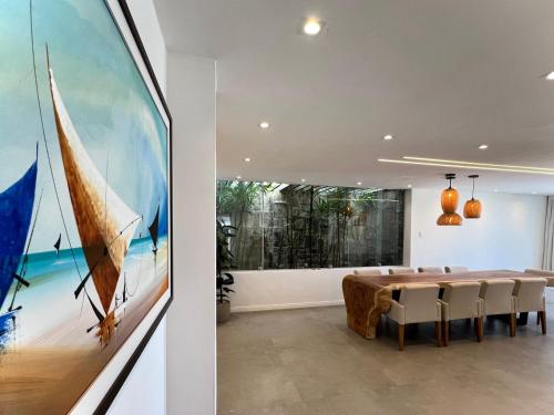 a dining room with a table and a painting at Residence Dunas Exclusive in Natal