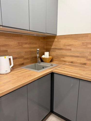 a kitchen with white cabinets and a sink at Apartmány U Kostela in Uničov