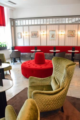 a waiting room with chairs and a red table at Theaterhotel & Suites Wien in Vienna