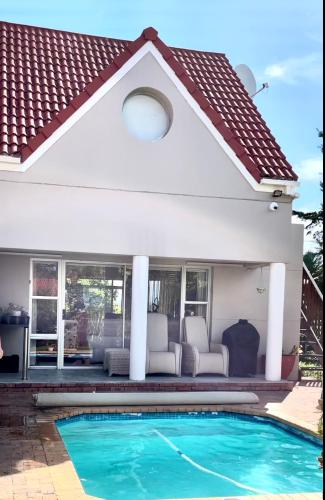 a swimming pool in front of a house at Rainbow Cottages - Kingfisher Drive in Sedgefield