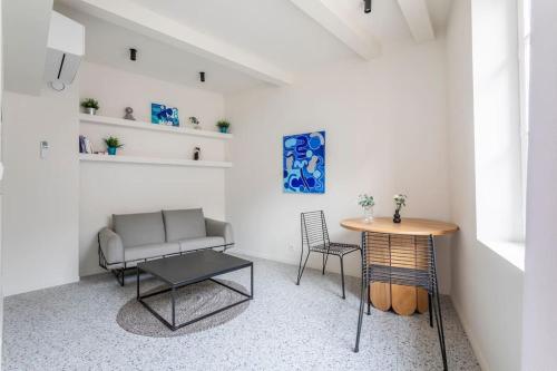 un salon avec un canapé et une table dans l'établissement 3CAPU3 - Cosy T2 refait à neuf - Noaille, à Marseille
