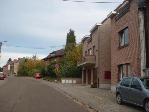 a car parked on the side of a street next to buildings at B&B La Chapelle Au Puits in La Louvière