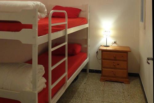 a room with two bunk beds and a night stand at Casa taller Penelles in Penellas