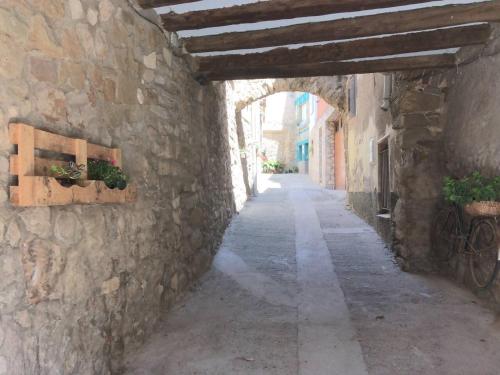 an alley with an archway in a stone building at Casa taller Penelles in Penellas