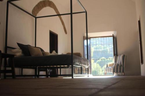 a bedroom with a bed in a room with a window at Lagar De Trevenez Montes De Malaga in Málaga