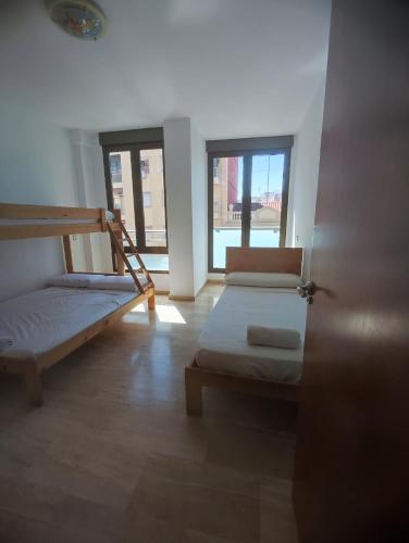 a room with two bunk beds and two windows at Close to the sea, large 170 m2 apartmentBIKES in Valencia