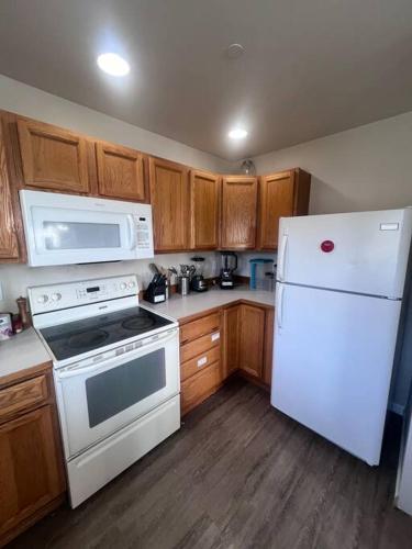 a kitchen with white appliances and wooden cabinets at Banquet Hotels Tacoma-Lakewood-Puyallup-DuPont-Lacey-Olympia in DuPont