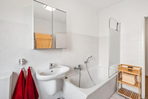 a white bathroom with a sink and a bath tub at WIESE 18 im Cottbuser Süden in Cottbus