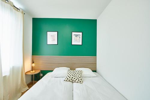- une chambre dotée d'un lit avec un mur vert dans l'établissement BE-3G - Appartement F2 pour 1-2 pers au 3ème étage au centre de Mulhouse, à Mulhouse