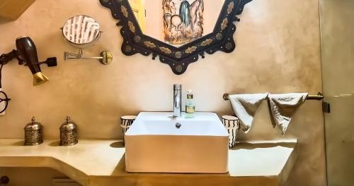 a bathroom with a tub and a sink with a mirror at Riad Le Grizzly in Marrakesh