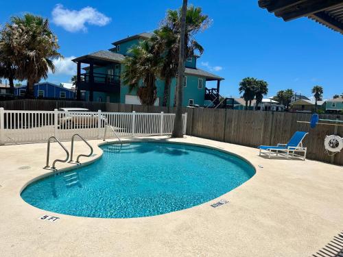 a small swimming pool with a chair and a house at Casa Palmera in Port Aransas