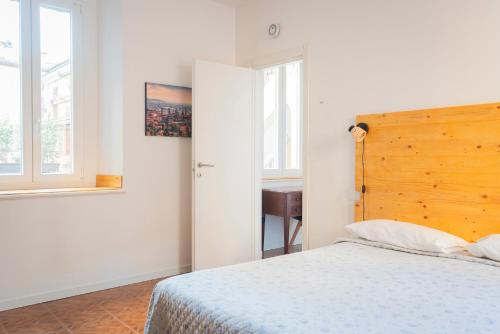 Un dormitorio con una cama con cabecero de madera y un escritorio. en Antiche Stalle IV, en Bérgamo