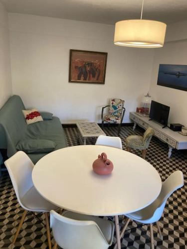 une table blanche et des chaises dans un salon dans l'établissement Appartement avec terrasse et jardin, à Saint-Raphaël