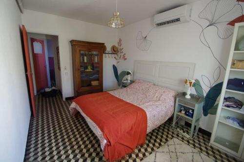 une chambre avec un lit avec une couverture rouge dans l'établissement Appartement avec terrasse et jardin, à Saint-Raphaël