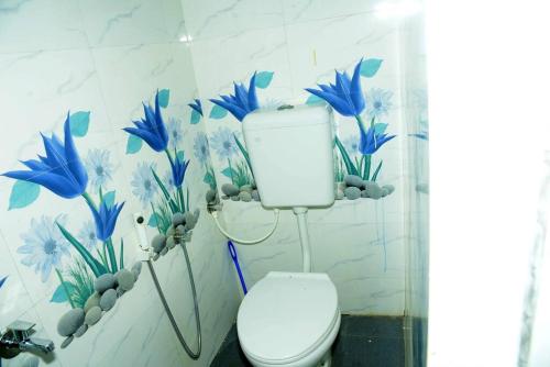 ein Badezimmer mit einem WC mit blauen Blumen an der Wand in der Unterkunft Sunset point view house in Kovakulam