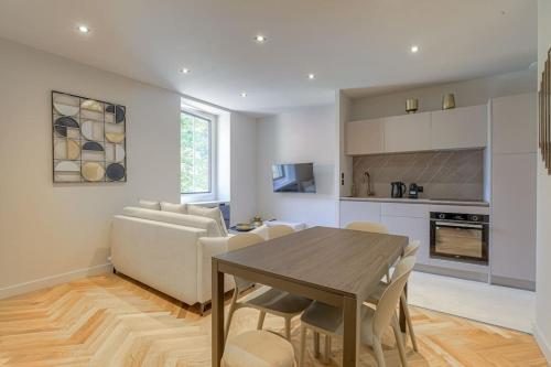 une cuisine et un salon avec une table et un canapé dans l'établissement Superbe appartement, deux chambres, St-Didier, à Saint-Didier-au-Mont-dʼOr