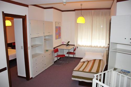 niewielka sypialnia z biurkiem, łóżkiem i stołem w obiekcie Albergo Residence Italia Vintage Hotel w mieście Pordenone