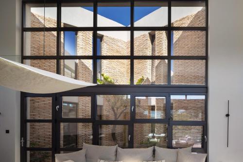 una grande finestra in un soggiorno con cuscini bianchi di Terra Segreda · slow living villa by ikies 3 a Volos