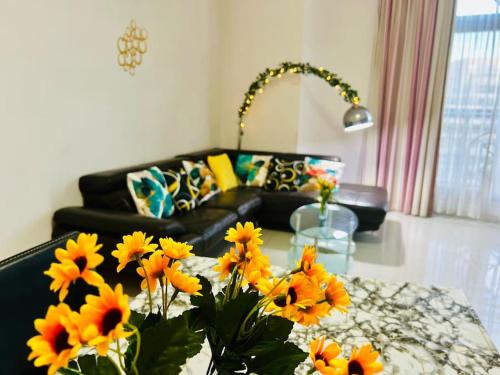 a living room with a couch and a table with flowers at Seaside Spinola APT in St Julians, Queen beds in St Julian's