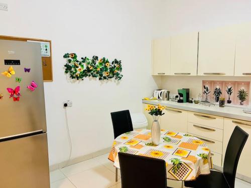 a kitchen with a table with chairs and a refrigerator at Seaside Spinola APT in St Julians, Queen beds in St Julian's