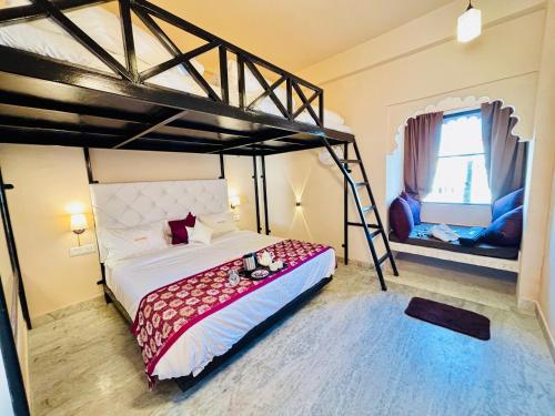 a bedroom with a bunk bed and two chairs at Hotel Nirvana Lakeside in Udaipur