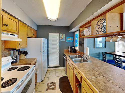 a kitchen with a white refrigerator and a sink at Coastal Cozy and a View in Padre Island