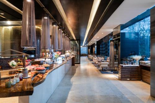 a restaurant with a long bar with tables and chairs at Hilton Mexico City Santa Fe in Mexico City
