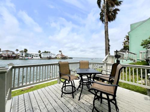 a table and chairs on a deck overlooking the water at Coastal Cozy and a View in Padre Island