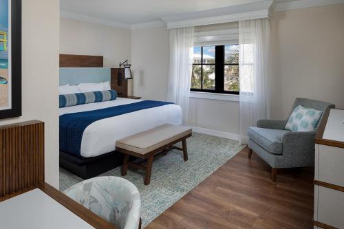 a hotel room with a bed and a chair at The Atlantic Suites on the Ave in Delray Beach