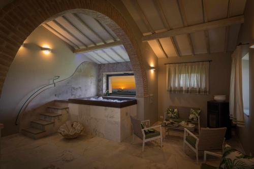 an archway in a room with a table and chairs at Villa I Cipressini piscina riscaldata spa Toscana in Pienza
