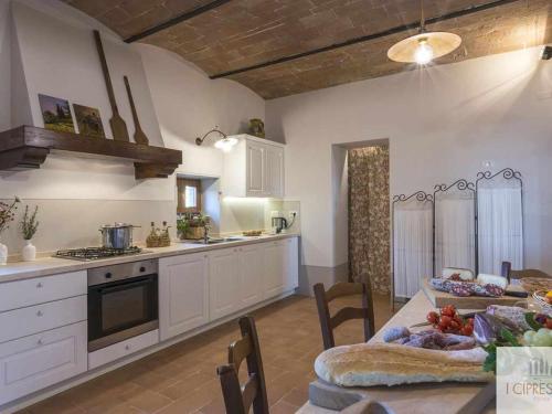 a kitchen and dining room with a table and a tableablish at Villa I Cipressini piscina riscaldata spa Toscana in Pienza