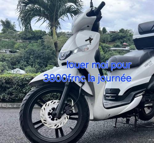 a white motor scooter parked in a parking lot at Nuutea lodge 2 in Avatoru