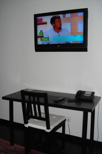 a desk with a chair and a television on a wall at B&B La Chapelle Au Puits in La Louvière