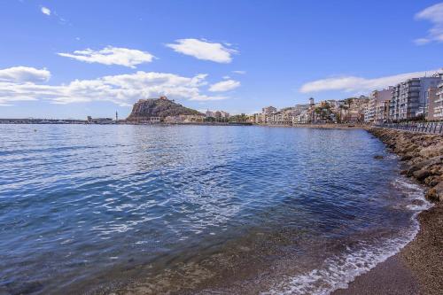 アギラスにあるÁguilas Delicias Piscina Wifi AC Parking Gratisの建物のある水の景色