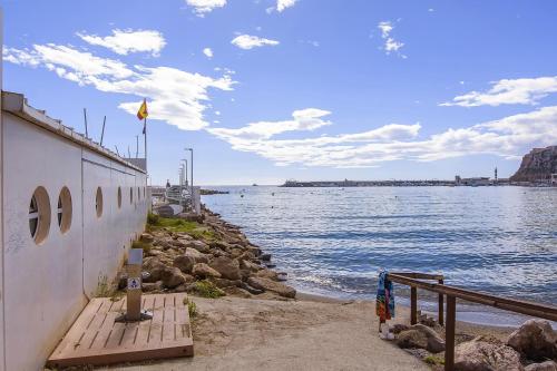 アギラスにあるÁguilas Delicias Piscina Wifi AC Parking Gratisの水の海岸の建物