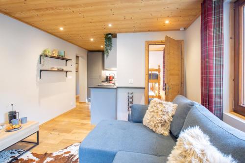 un salon avec un canapé bleu et une cuisine dans l'établissement Cosy 2 bed apartment situated in Morzine old town, à Morzine