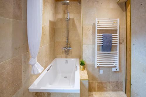 une salle de bain avec une baignoire blanche et une douche dans l'établissement Cosy 2 bed apartment situated in Morzine old town, à Morzine