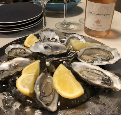 a plate of oysters on a plate with lemon slices at Villa Algarve 4 Ensuite Bedrooms, Private Swimming Pool, Beautiful Gardens with water features and natural Bio Pool in Almancil