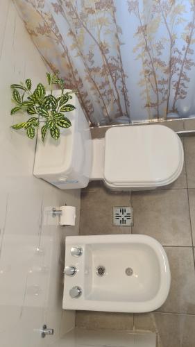 a bathroom with a white sink and a toilet at Sundara Tan perfecto que no vas a querer irte in Villa Carlos Paz