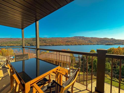 a balcony with a table and chairs and a view of a lake at Magnifique VUE LAC et SKI in Mont-Tremblant