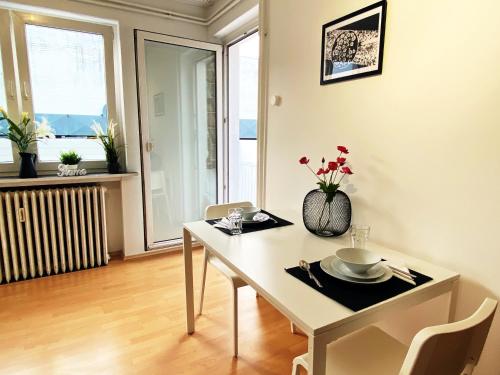 a white dining room with a table and chairs at Geräumige Monteurwohnung in infrastrukturell bester Lage in Lengerich