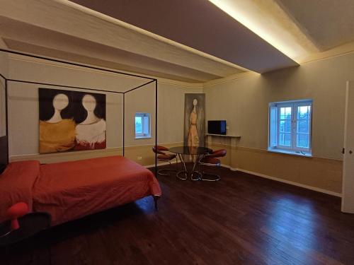 a bedroom with a bed and a table and a painting at Santo Stefano Rondini in Vicoforte
